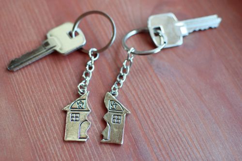 Two keys with a pendant in the shape of a house divided in two parts - Fremstad Law