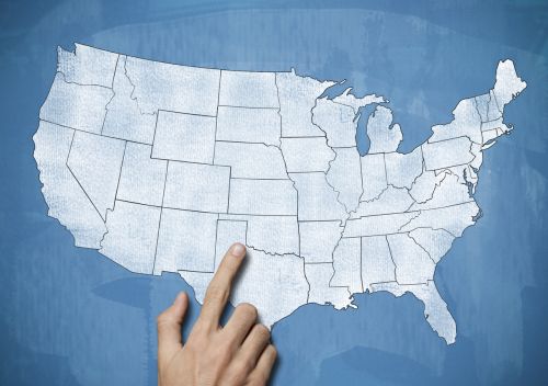 Male hand pointing on USA map - out of state concept