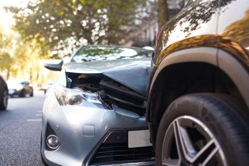 Two damaged vehicles in car accident after collision on city street. Comparative Negligence Concept